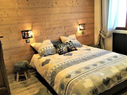 - une chambre avec un lit et un mur en bois dans l'établissement Chalet cosy 4* à 100m des pistes, avec sauna, WIFI et parking privé - FR-1-267-269, à Villarembert