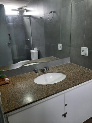 a bathroom counter with a sink and a mirror at Loft centro de Goiânia 1108 in Goiânia