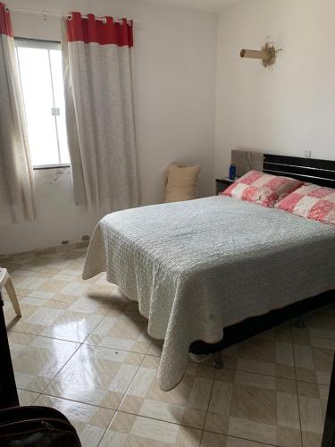 a bedroom with a bed and a window at Casa em Unamar Cabo Frio in Cabo Frio