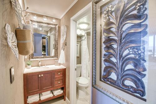 a bathroom with a toilet and a painting on the wall at Daytona Beach Retreat Beach Access! in Daytona Beach