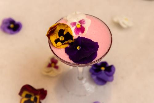 a glass filled with a pink drink with purple flowers at Waldorf Astoria Orlando - An Official Walt Disney World Hotel in Orlando