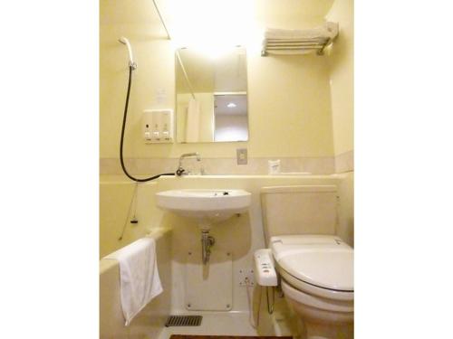 La salle de bains est pourvue d'un lavabo, de toilettes et d'un miroir. dans l'établissement Hotel Wakow - Vacation STAY 22137v, à Yonago