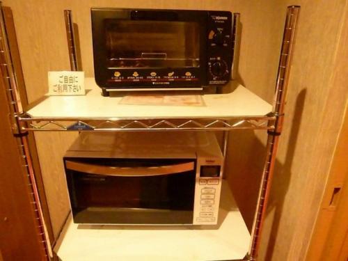 un forno a microonde su una mensola con un forno a microonde di Hotel Wakow - Vacation STAY 22128v a Yonago