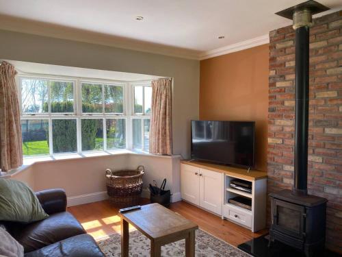 sala de estar con TV de pantalla plana y chimenea en Countryside Home located just outside Dublin City, en Dunboyne