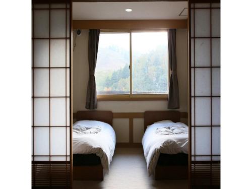 um quarto com duas camas e uma janela em Shiga Palace Hotel - Vacation STAY 22531v em Shiga Kogen