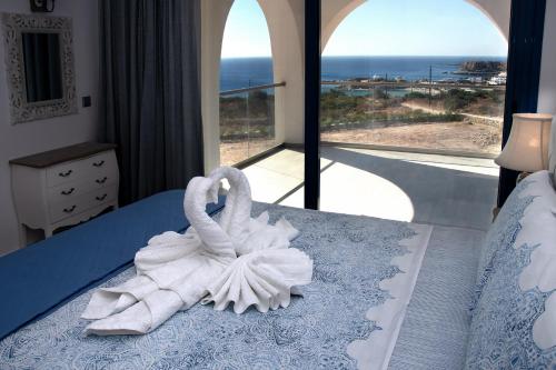 two swans towels sitting on a bed in a bedroom at Aelia Luxury Villa in Amoopi