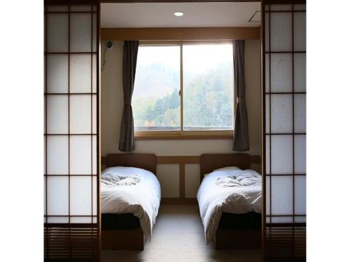a room with two beds and a window at Shiga Palace Hotel - Vacation STAY 22530v in Shiga Kogen