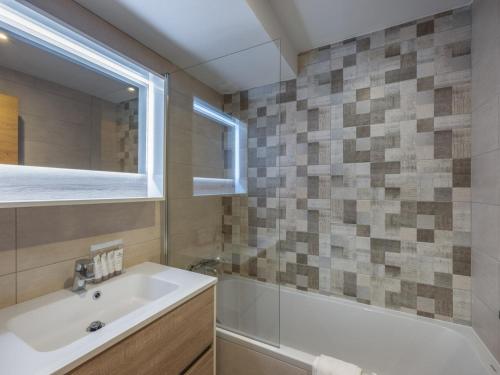 une salle de bain avec un lavabo, une baignoire et un miroir dans l'établissement Appartement moderne 6 pers proche pistes avec parking, casier à ski, balcon - FR-1-563-140, à Courchevel