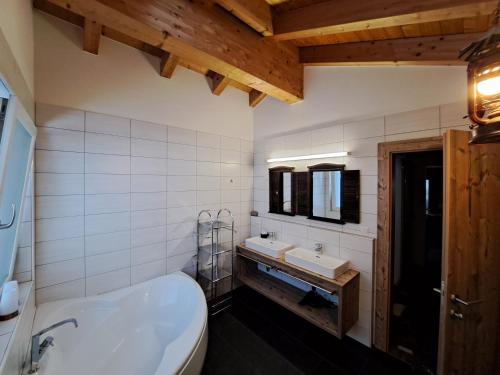 a bathroom with a white tub and a sink at Rooftop by Northsouth Apartments in Sölden