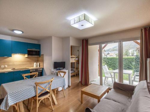 une cuisine et un salon avec une table et un canapé dans l'établissement T3 avec Jardin, Piscine, Sauna, Hammam - Proche Commodités, Ski et Thermes - 4 Pers, Luz-Saint-Sauveur - FR-1-402-135, à Luz-Saint-Sauveur