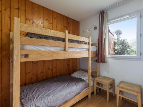 une chambre avec deux lits superposés et une fenêtre dans l'établissement T3 avec Jardin, Piscine, Sauna, Hammam - Proche Commodités, Ski et Thermes - 4 Pers, Luz-Saint-Sauveur - FR-1-402-135, à Luz-Saint-Sauveur