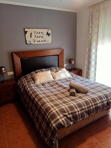 een slaapkamer met een bed met een geruite deken bij Chalet Adosado en Rincón in Rincón de la Victoria