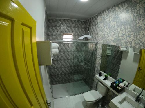 a bathroom with a shower and a toilet and a sink at Mecejana Home in Boa Vista
