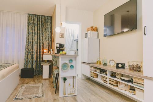 a small room with a white refrigerator and a table at Cochet Studio in Focşani