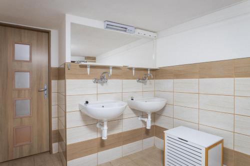 La salle de bains est pourvue de 2 lavabos et d'un miroir. dans l'établissement Turistická chata Nesnídalka, 