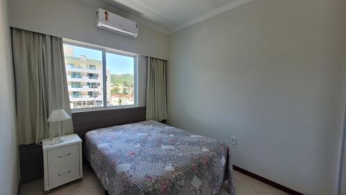 a bedroom with a bed and a large window at B720 - Apartamento 2 quartos em cond. com piscina in Bombas