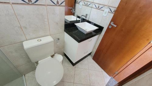 a bathroom with a white toilet and a sink at B720 - Apartamento 2 quartos em cond. com piscina in Bombas