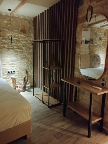 a bedroom with a desk and a mirror at Ekali stone house in Kalentzi