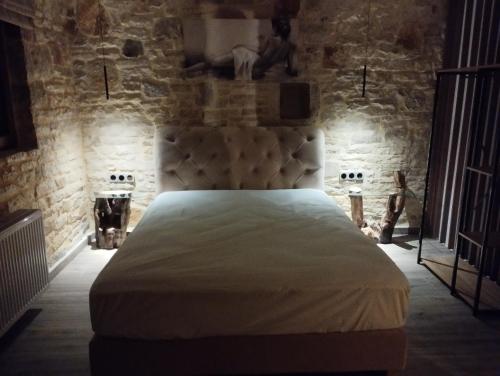 a bedroom with a large bed in a stone wall at Ekali stone house in Kalentzi