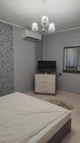 1 dormitorio con 1 cama, vestidor y TV en Къща под наем-нощувки en Targovishte