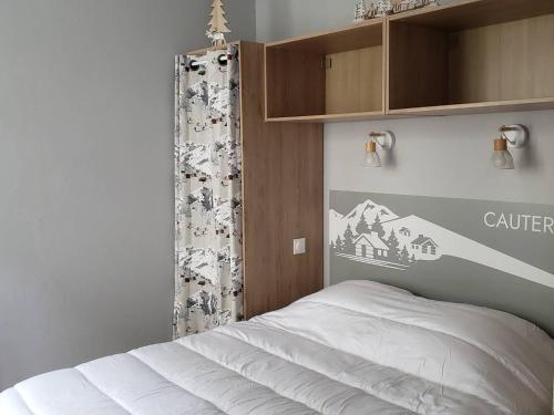 - une chambre avec un lit blanc et une armoire dans l'établissement Charmant T2 au centre de Cauterets avec parking, ascenseur et équipements modernes - FR-1-234-312, à Cauterets