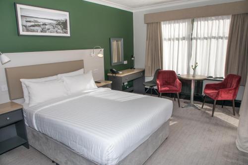 a hotel room with a bed and a table and chairs at Park Inn by Radisson Bournemouth in Bournemouth