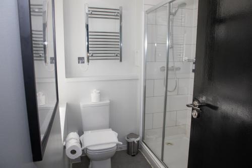La salle de bains blanche est pourvue d'une douche et de toilettes. dans l'établissement Park Inn by Radisson Bournemouth, à Bournemouth