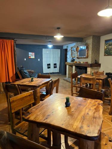 uma sala de jantar com mesas e cadeiras de madeira em HOSTEL PEHUENIA em El Bolsón