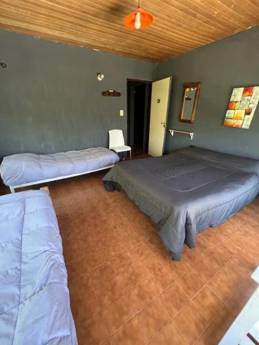 two beds are in a room with at HOSTEL PEHUENIA in El Bolsón