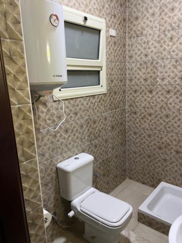 a bathroom with a toilet and a window and a sink at Room in new Cairo near the airport in Cairo