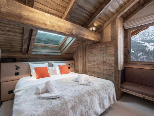 ein Schlafzimmer mit einem großen Bett mit Fenster in der Unterkunft Grand Chalet Méribel, 15 pers, Navette privée - FR-1-565-102 in Les Allues