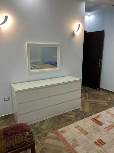 una camera bianca con cassettiera e specchio di Room in new Cairo near the airport a Il Cairo