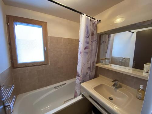 a bathroom with a tub and a sink and a window at Appartement Crest-Voland, 3 pièces, 4 personnes - FR-1-733-150 in Crest-Voland