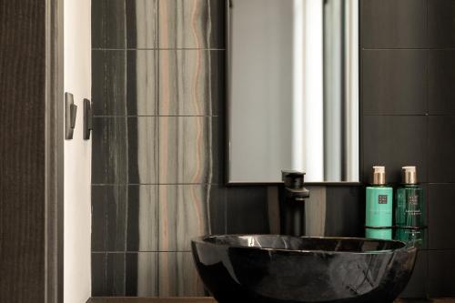 a bathroom with a bowl sink and a window at Pleiades Urban Stay by Semavί in Heraklio Town