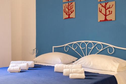 - une chambre bleue avec un lit et des serviettes dans l'établissement B&B La Rosa Lampedusa, à Lampedusa