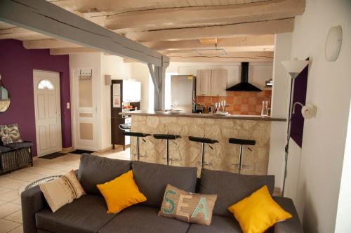 a living room with a couch and a kitchen at Maison de village à Puybrun in Puybrun