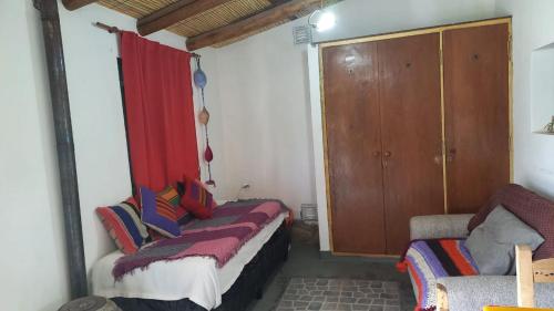 a room with two beds and a red curtain at Cabaña Los Girasoles Cachi Salta in Cachí