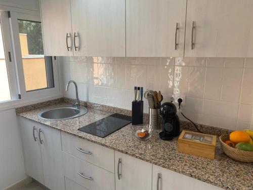 a kitchen counter with a sink and a bowl of fruit at La Fortaleza House MOGAN in Mogán