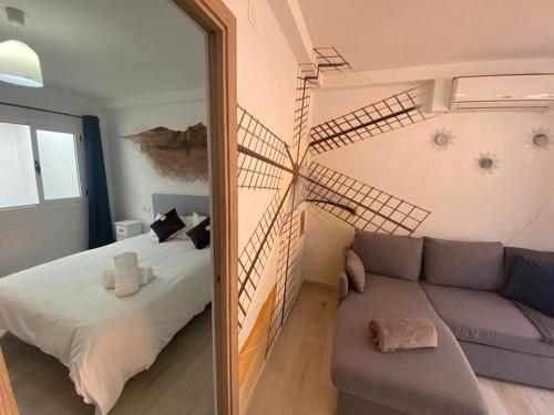 a bedroom with a staircase and a couch and a mirror at La Fortaleza House MOGAN in Mogán