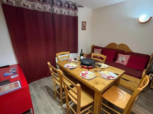 - une salle à manger avec une table, des chaises et un canapé dans l'établissement Alpe d'Huez - Confortable appartement à 150m des pistes - la Marmotte en Folie, à L'Alpe-d'Huez
