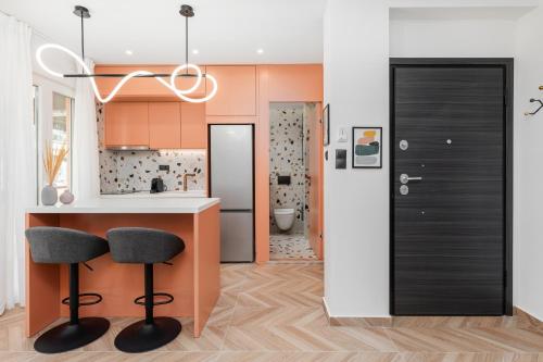 a kitchen with a counter and two bar stools at Oasis Diamond Suite in Thessaloniki