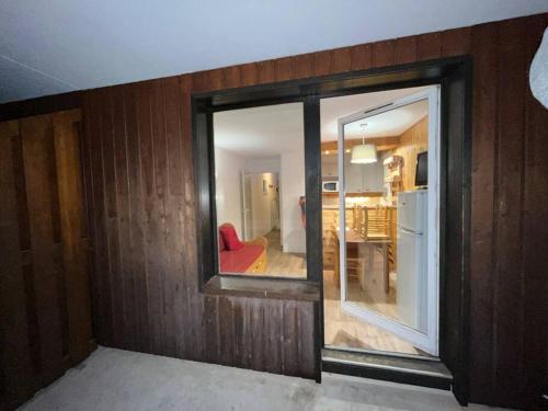 une chambre avec un miroir et un salon dans l'établissement Alpe d'Huez - Confortable appartement à 150m des pistes - la Marmotte en Folie, à L'Alpe-d'Huez