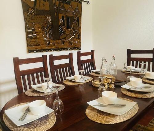 una mesa de madera con platos, cuencos y servilletas en La Villa Tila, en Ouoran