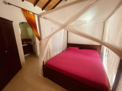 Ouoran的住宿－La Villa Tila，卧室配有粉红色的床。