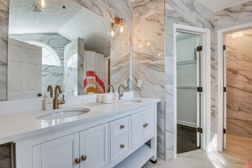 a white bathroom with a sink and a mirror at College Park Home 13 Mi to Downtown Atlanta! in College Park