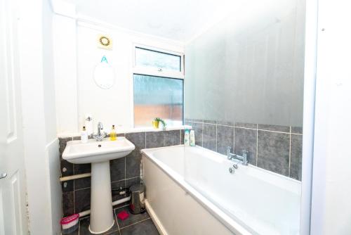 a bathroom with a tub and a sink and a bath tub at Bright Medway studio flat opposite Chatham station in Chatham