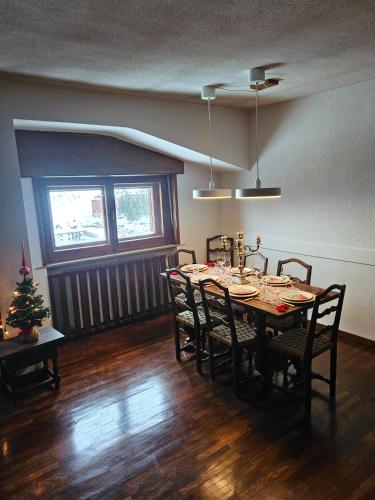 une salle à manger avec une table, des chaises et un arbre de Noël dans l'établissement Cervino 1865 - Family House, à Breuil-Cervinia
