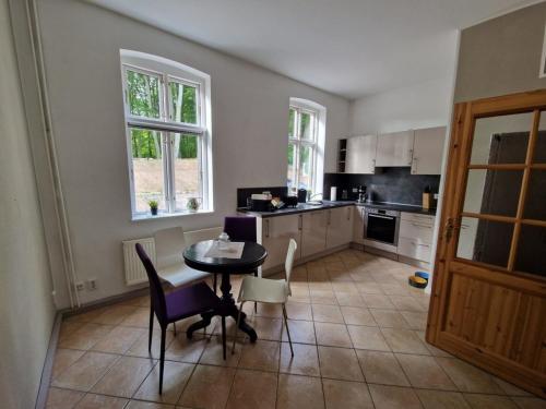 uma cozinha com mesa e cadeiras num quarto em Ferienwohnung "Gartenblick" em Marlow