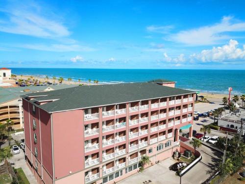 Quality Inn & Suites Galveston - Beachfront في جالفيستون: اطلالة جوية على الفندق والشاطئ