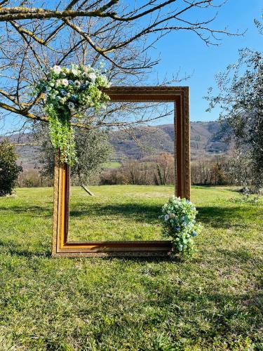 a mirror frame with flowers on it in a field at Tenuta delle Acque in Acquasparta